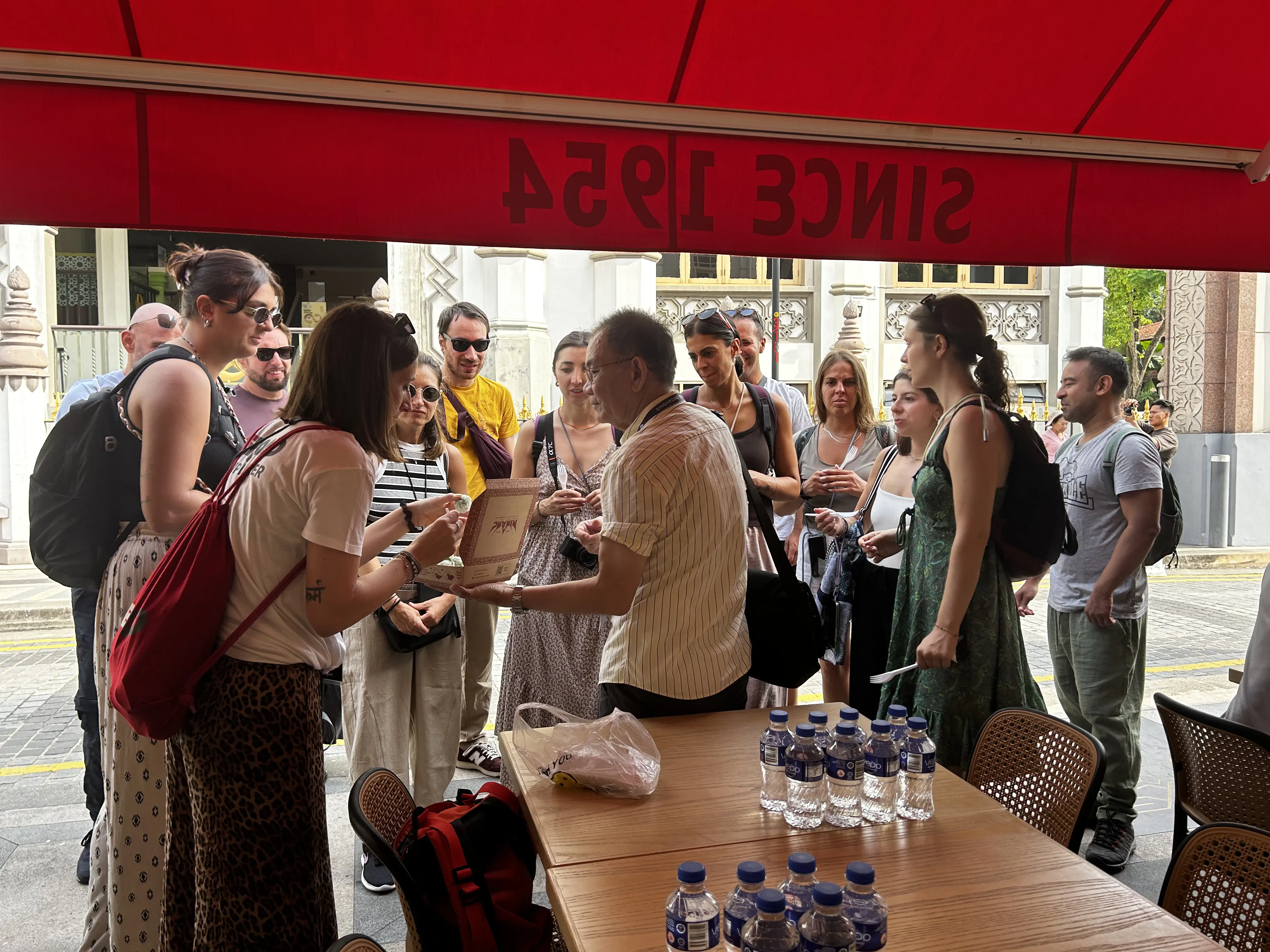 Tour group tasting kueh together during their heritage walk